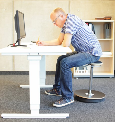 Homem senta-se à secretária do computador, tem um trabalho sedentário