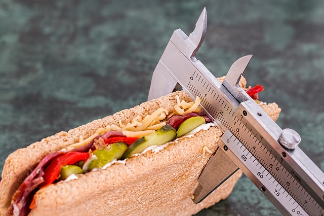 Estados de doença como consequência do aumento de peso mesmo com uma dieta equilibrada. Fonte da foto: Getty Images Sanduíche, medidor, aumento de peso como consequência da doença