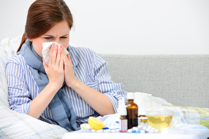 A rinite como sintoma de várias doenças. Fonte: Getty Images Uma mulher limpa o nariz, por causa de uma constipação, que é a causa de várias doenças. Na imagem há medicamentos, comprimidos, garrafa, spray, limão