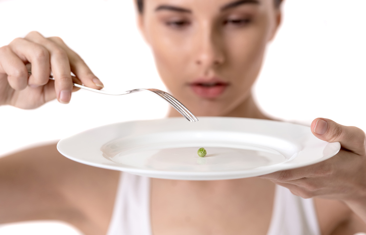 Mulher com ervilhas no prato, restrição alimentar