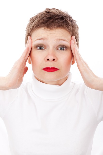 Dores de cabeça, zumbidos e zumbidos associados = exame. Fonte da foto: Thinkstock Photos a mulher segura a cabeça com as mãos, dói-lhe a cabeça, os seus lábios estão pintados de vermelho